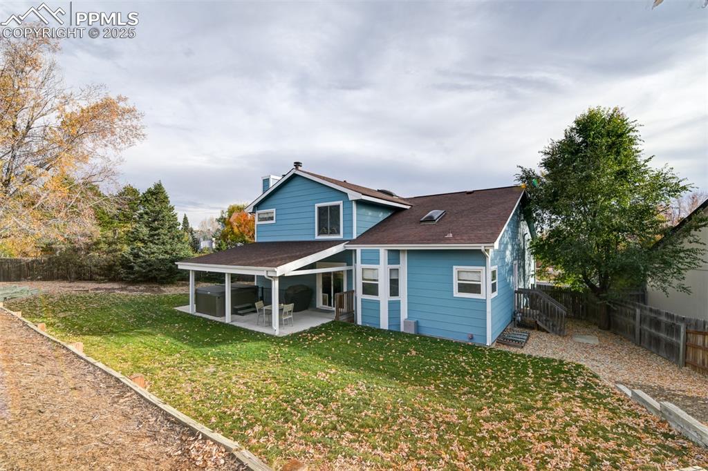 Image 49 of 50: Rear view of property with a fenced backyard, roof with shingles, and a pat