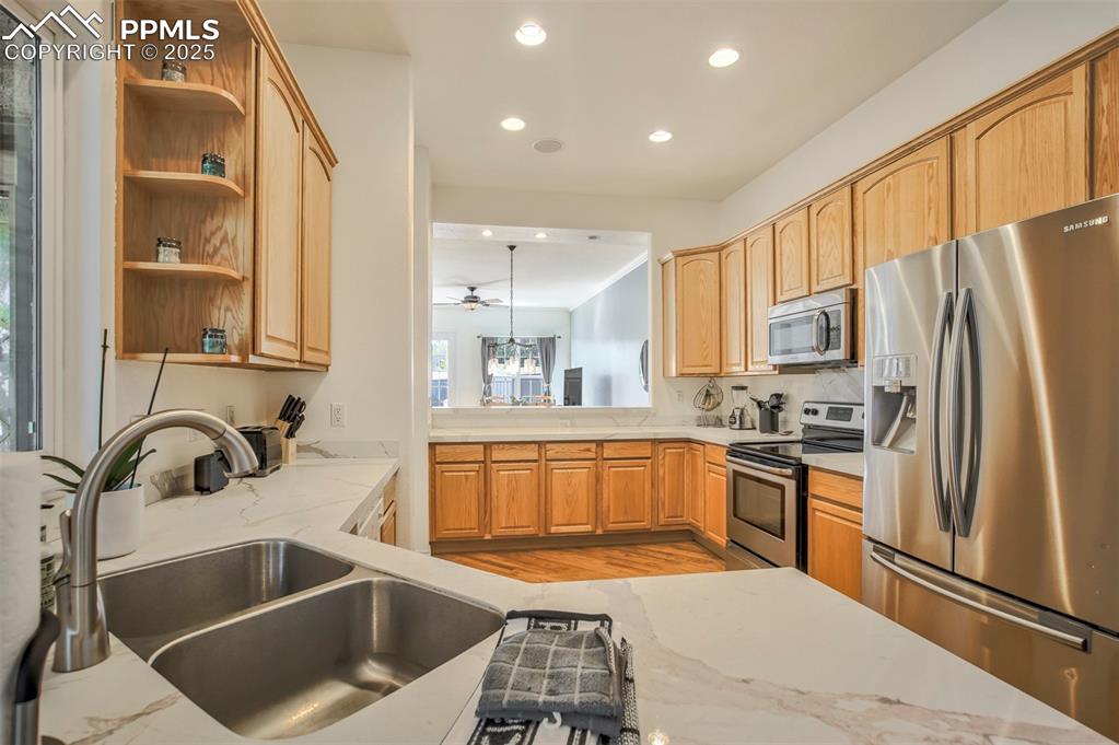 Image 12 of 33: ceiling fan, and light stone countertops