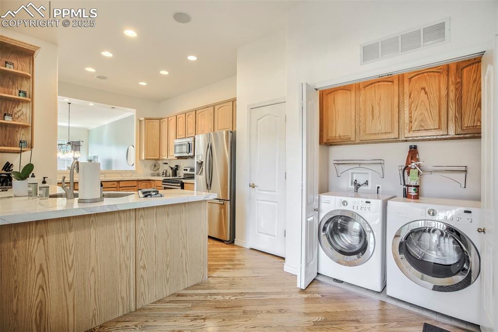 Image 20 of 33: Laundry room featuring washer and dryer, recessed lighting, and light wood-
