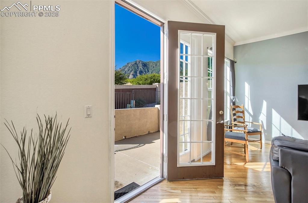 Image 31 of 33: Doorway walking out to rear patio, wood finished floors, and plenty of natu