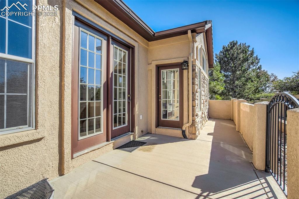 Image 33 of 33: Doorway to property featuring stucco siding and a gate