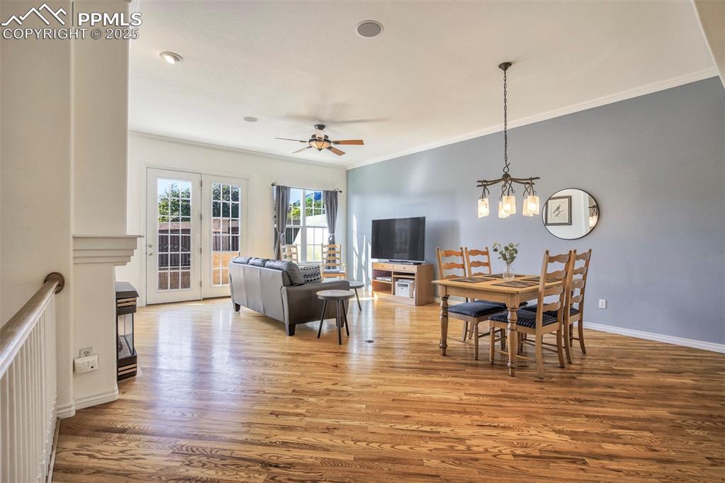 Image 6 of 33: Dining room with ornamental molding, wood finished floors, a chandelier, an