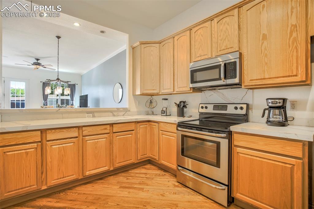 Image 7 of 33: Kitchen with appliances with stainless steel appliance and solid surface co