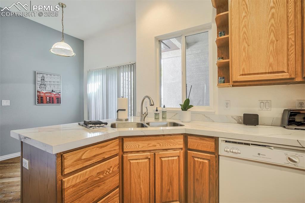 Image 9 of 33: Kitchen featuring white dishwasher, wood finished floors, plenty of natural