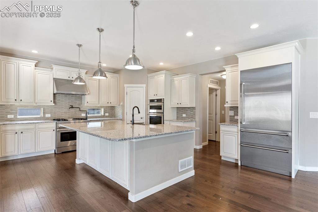 Image 18 of 49: Well-appointed gourmet kitchen featuring a spacious center island, stainles