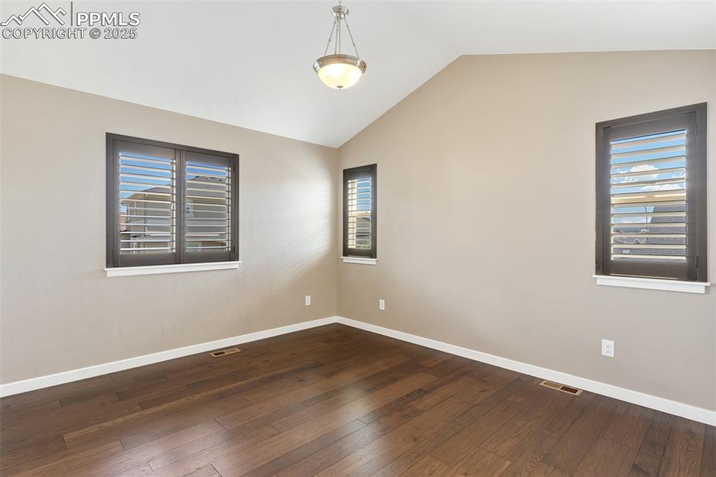 Image 27 of 49: Spacious bedroom featuring lots of natural light and a vaulted ceiling