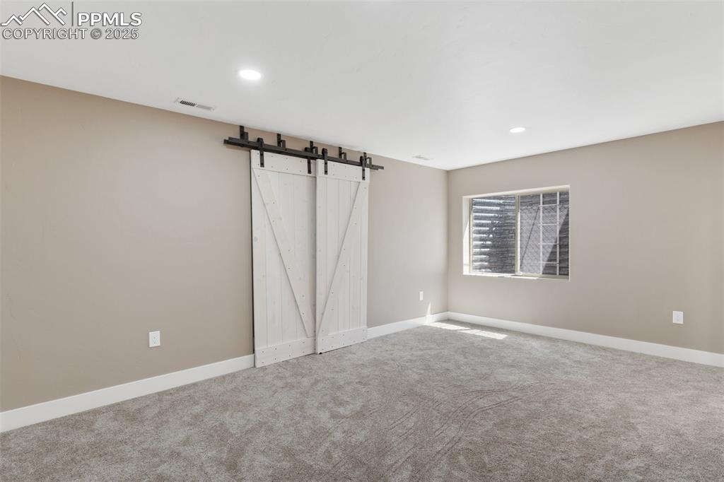 Image 35 of 49: Bedroom featuring a closet with a barn door and ensuite Jack-and-Jill bathr
