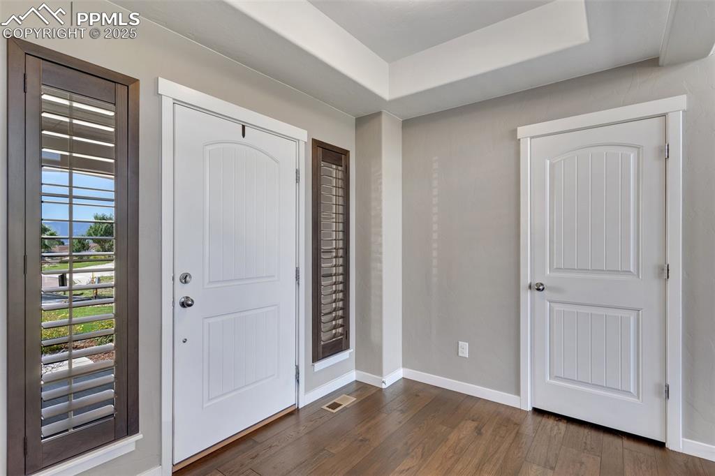 Image 8 of 49: Beautiful foyer featuring tray ceiling, upgraded shutter blinds, coat close