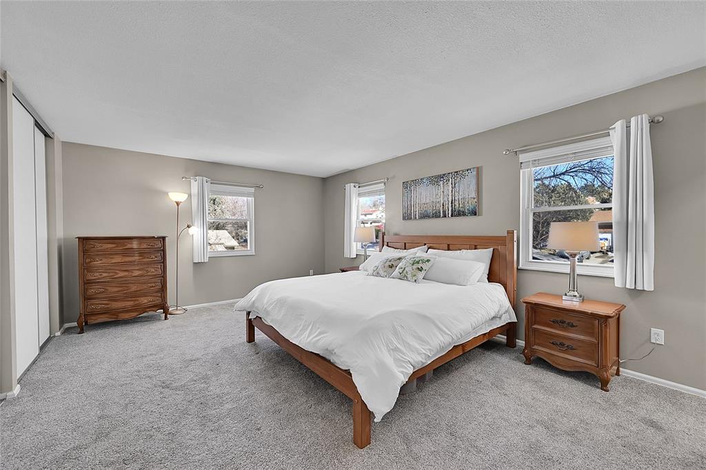 Image 18 of 45: Lots of windows makes the primary bedroom light and bright!