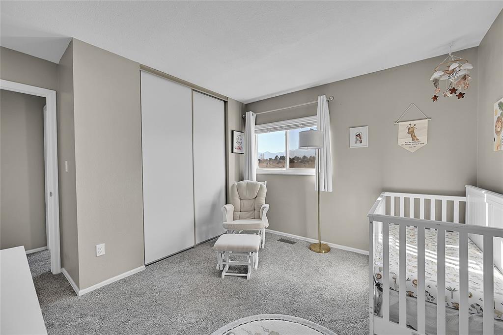 Image 23 of 45: Carpeted bedroom featuring a crib and a closet