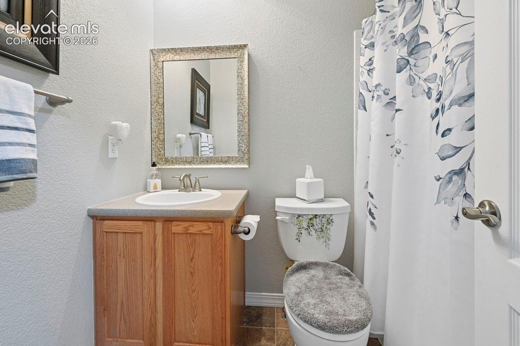 Image 13 of 39: Single vanity with wood-finish cabinetry, integrated sink, and brushed nick