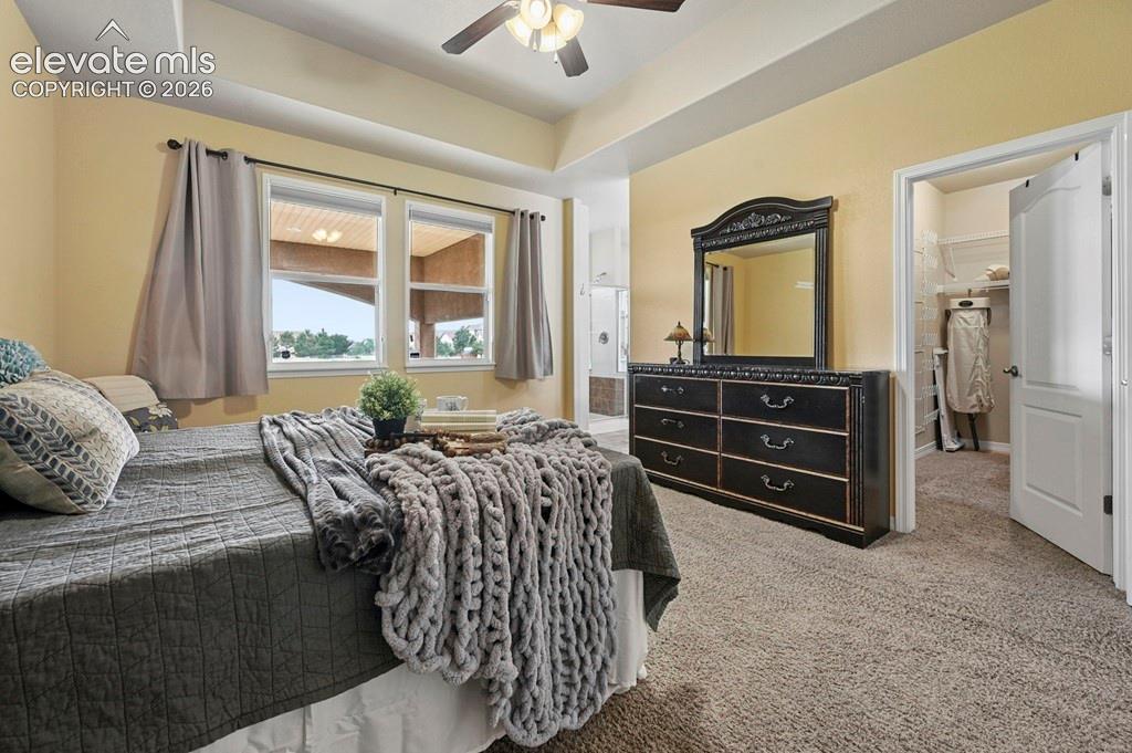 Image 16 of 39: Recessed ceiling with an attached fan, dual windows, and an open doorway le