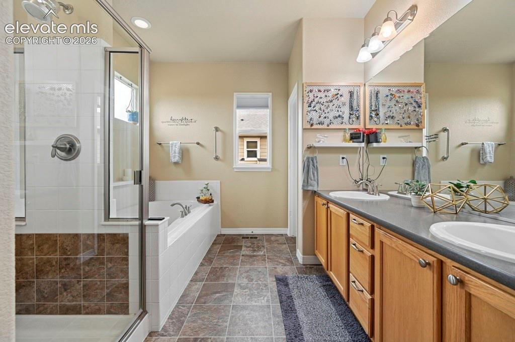 Image 20 of 39: Dual vanity with integrated sinks, wood-finish cabinetry, a glass-enclosed 