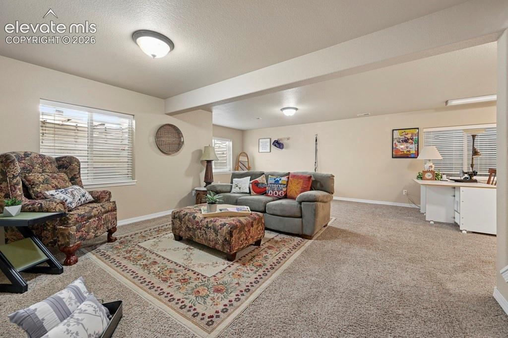 Image 25 of 39: Spacious room with light-colored walls and windows
