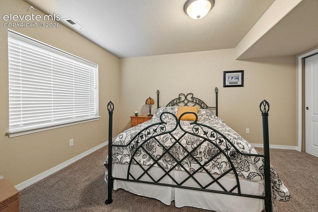 Image 28 of 39: Basement bedroom with neutral wall finishes, white window blinds, recessed