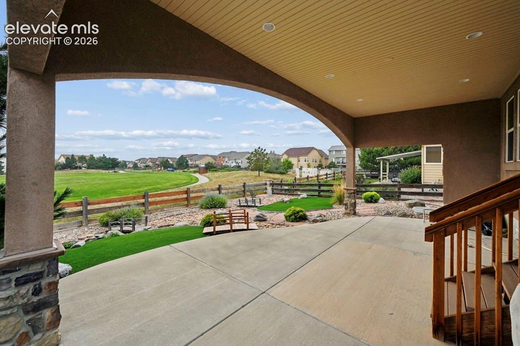 Image 32 of 39: Covered patio, concrete, and stone-clad columns