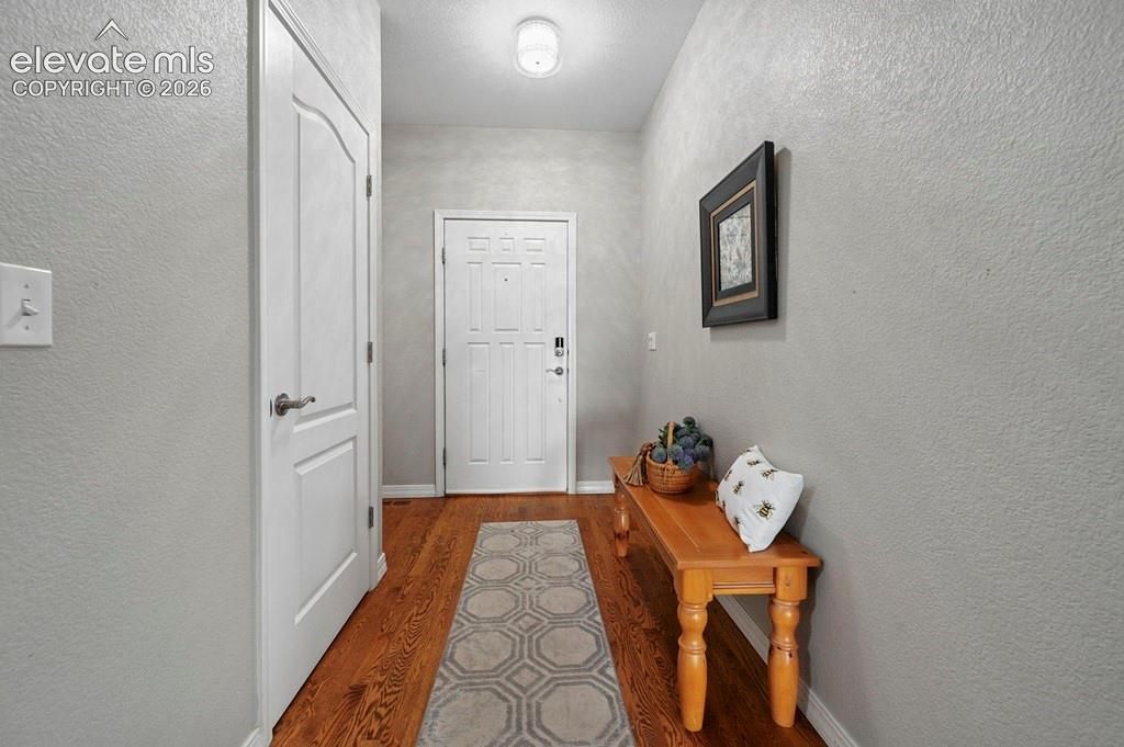 Image 4 of 39: Wood-finish flooring with a light gray wall finish, white interior doors, a