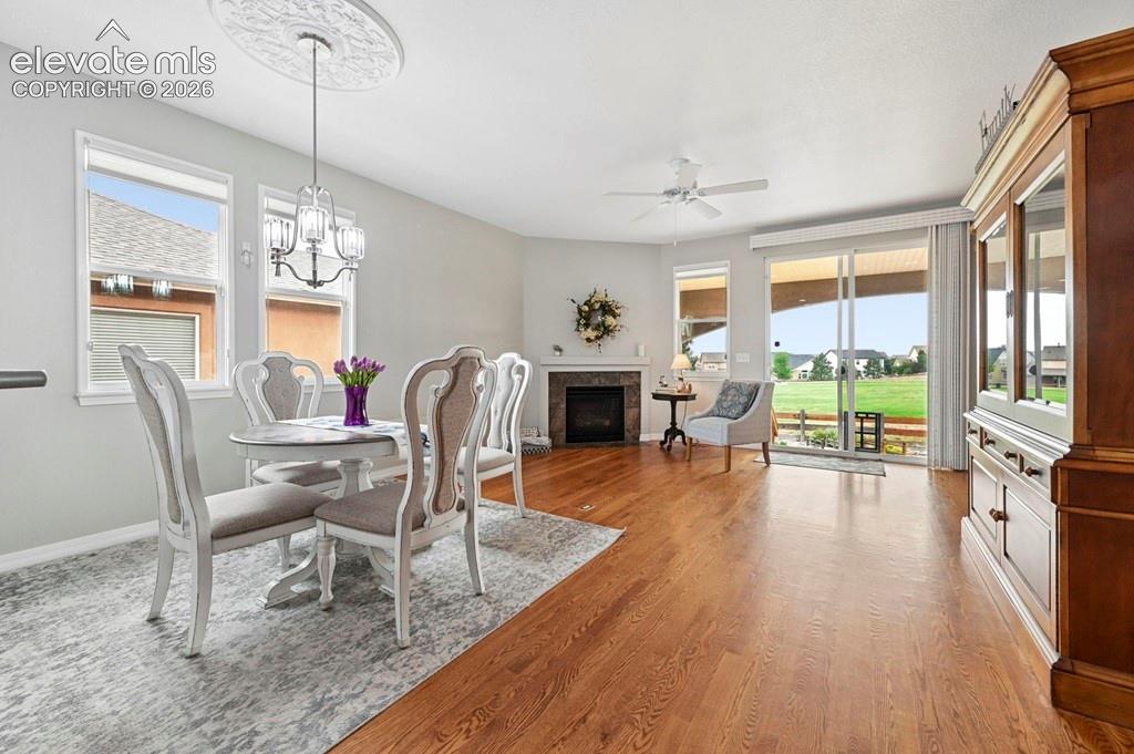 Image 5 of 39: Hardwood-finish flooring, built-in fireplace with tile surround, ceiling fa