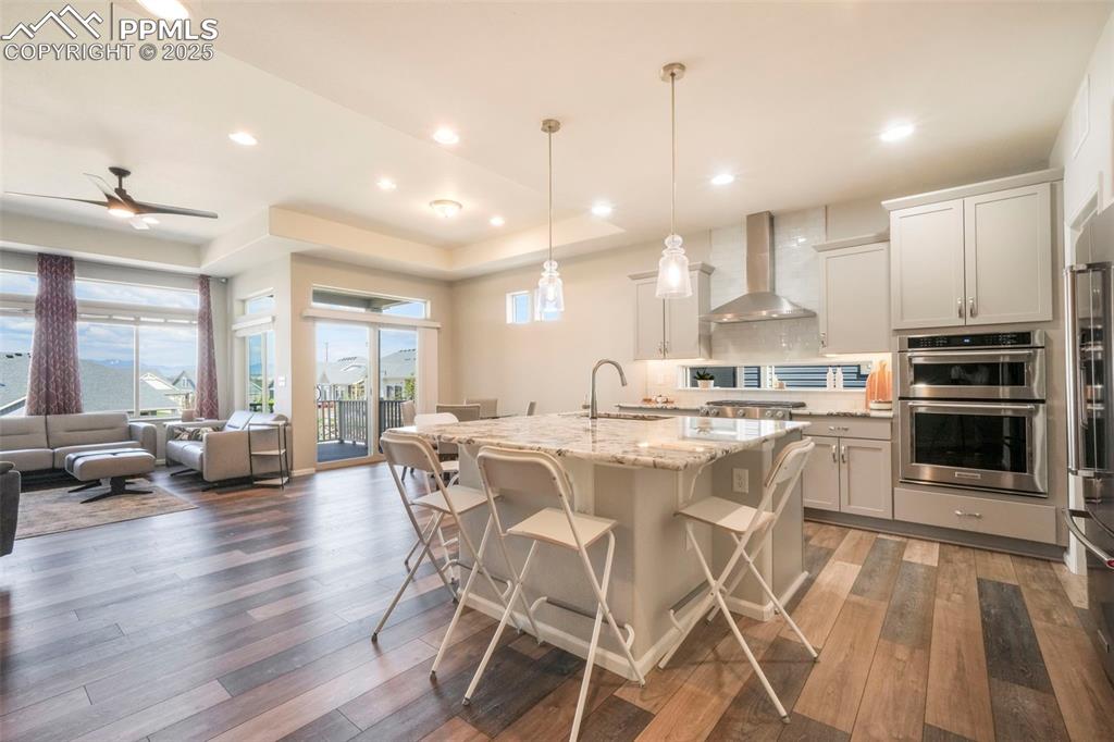 Image 10 of 50: Kitchen with granite counters, gas cooktop, stainless steel appliances, pan