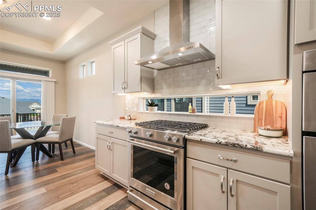 Image 11 of 50: Kitchen with granite counters, gas cooktop, stainless steel appliances, pan