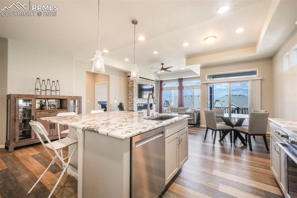 Image 12 of 50: Kitchen with granite counters, gas cooktop, stainless steel appliances, pan