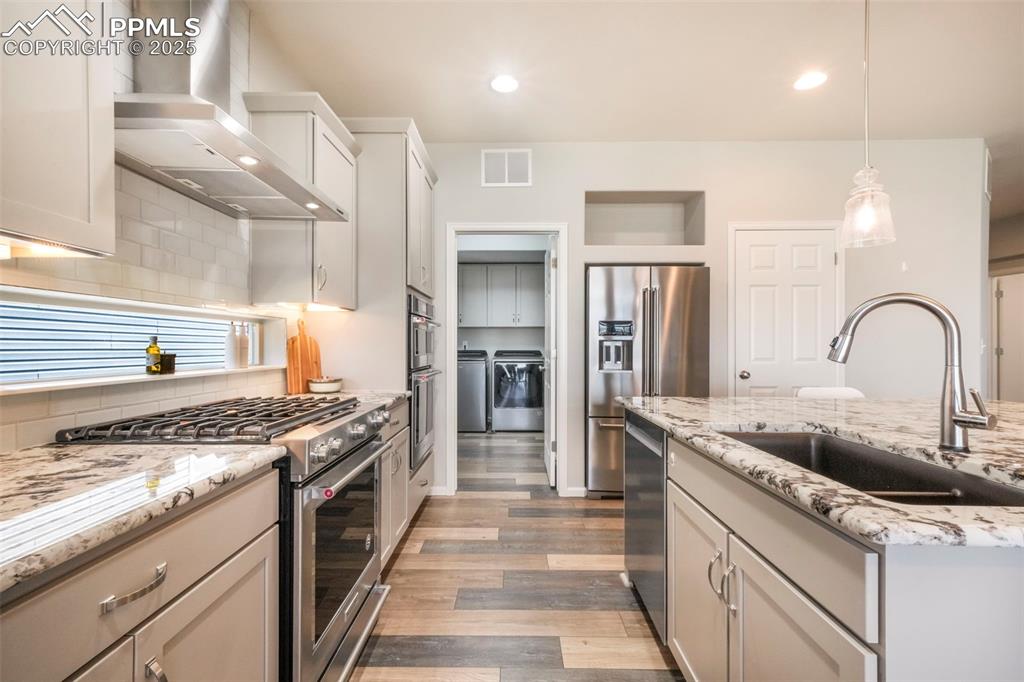 Image 13 of 50: Kitchen with granite counters, gas cooktop, stainless steel appliances, pan