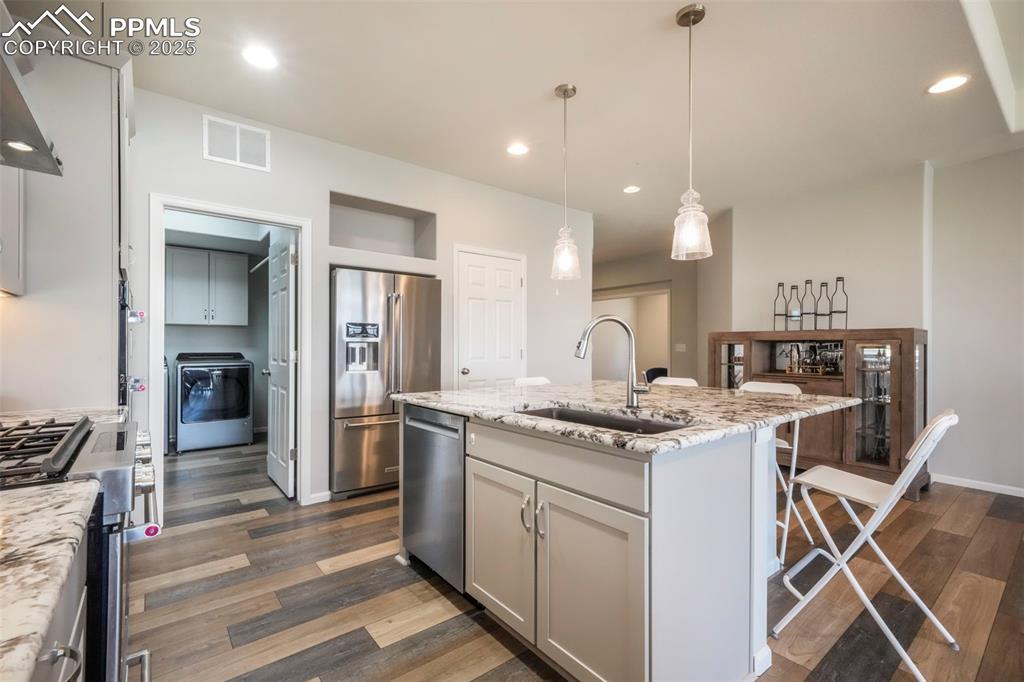 Image 14 of 50: Kitchen with granite counters, gas cooktop, stainless steel appliances, pan