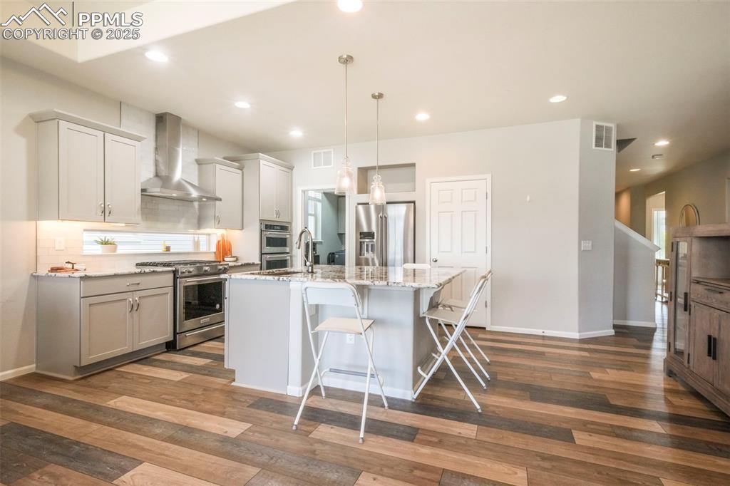 Image 15 of 50: Kitchen with granite counters, gas cooktop, stainless steel appliances, pan