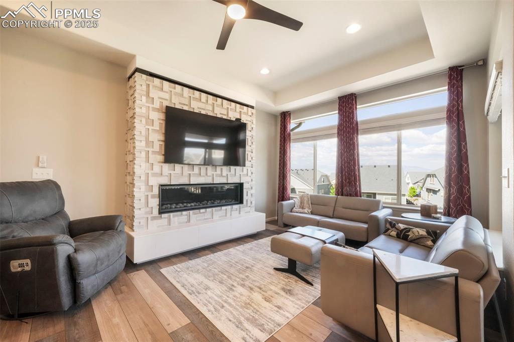 Image 18 of 50: Living room with mountain views, large fireplace, walk out access to deck