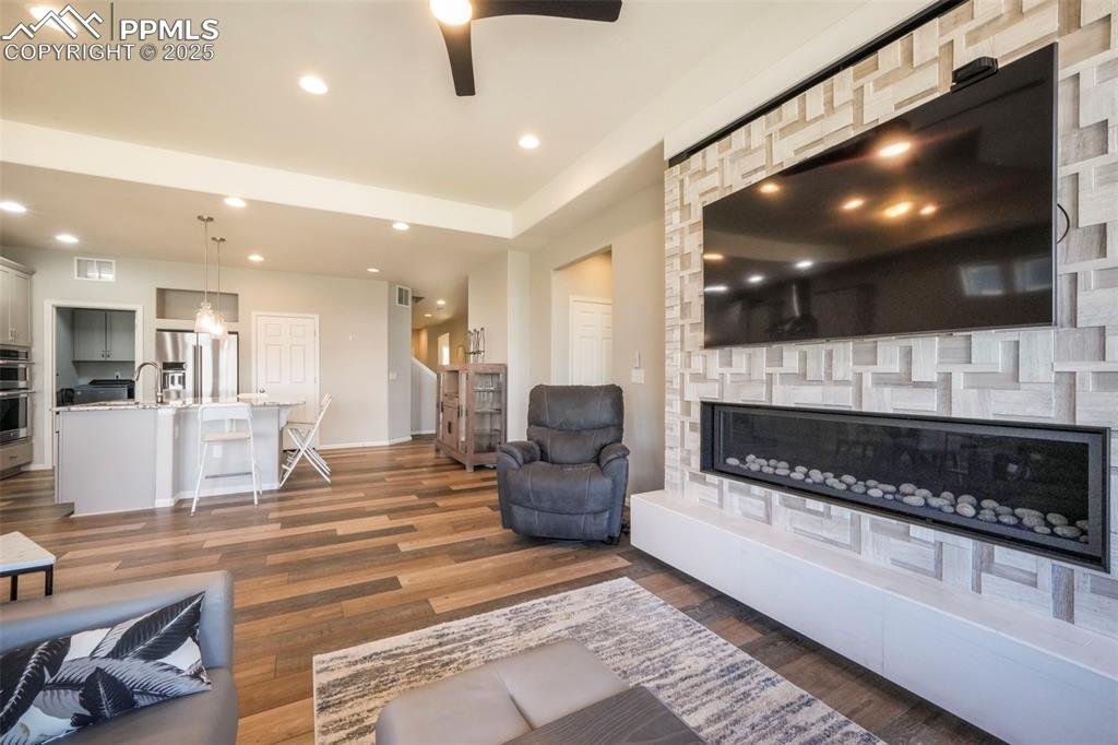 Image 21 of 50: Living room with mountain views, large fireplace, walk out access to deck