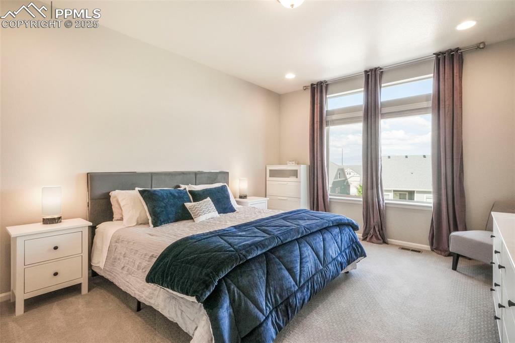 Image 23 of 50: Main level primary bedroom with ensuite and large walk in closet