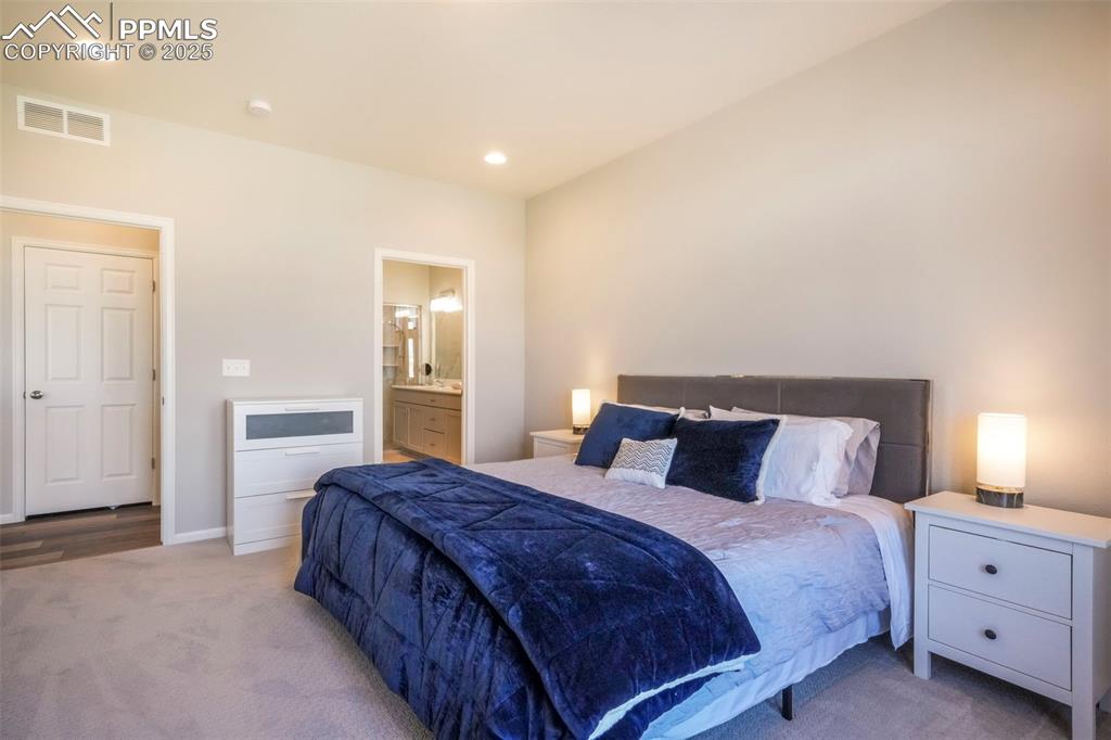 Image 25 of 50: Main level primary bedroom with ensuite and large walk in closet