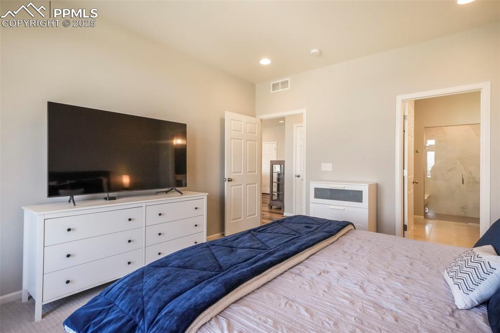 Image 26 of 50: Main level primary bedroom with ensuite and large walk in closet
