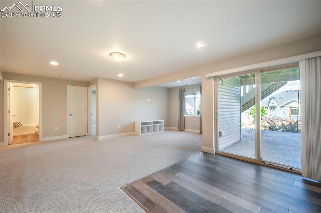 Image 35 of 50: Basement family room with wet bar, walk out access to back patio and landsc