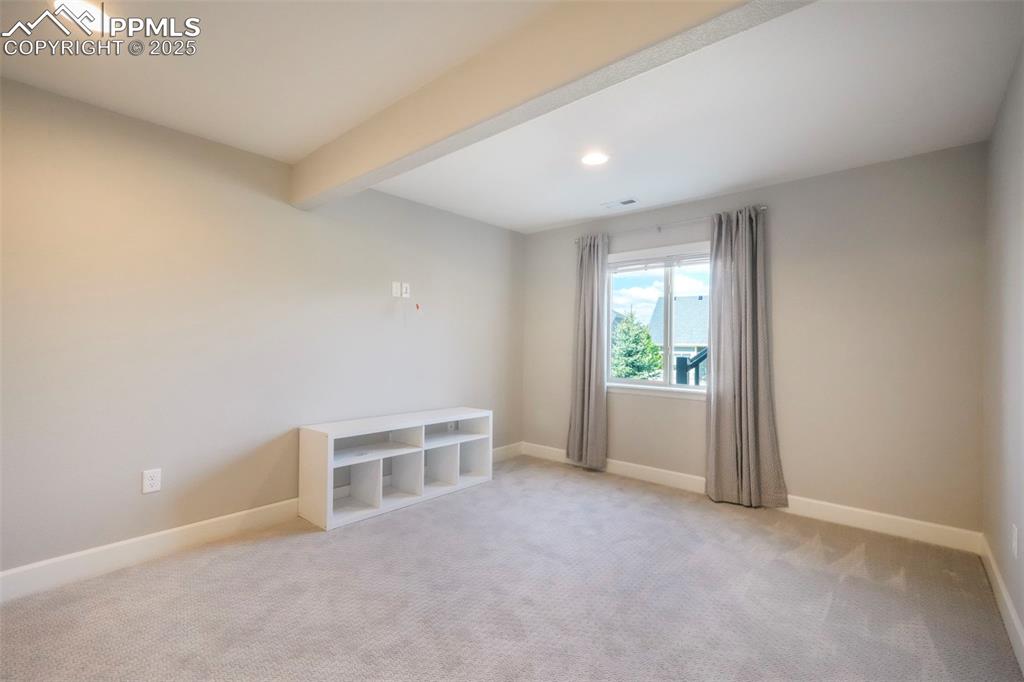 Image 36 of 50: Basement family room with wet bar, walk out access to back patio and landsc
