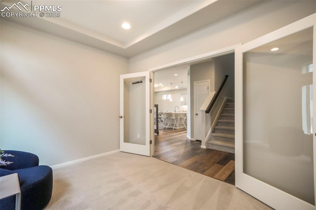 Image 9 of 50: Main level sitting room, office, formal dining, flex space with French door