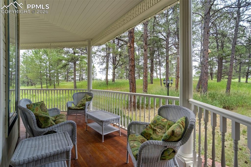 Image 5 of 50: Covered front porch with hot tub