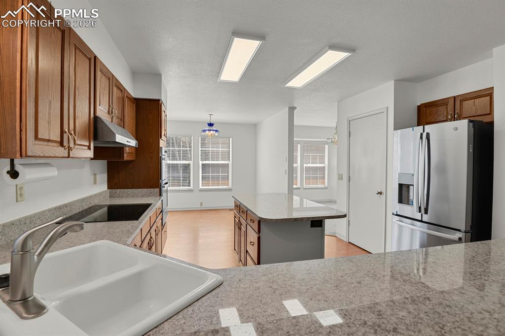 Image 12 of 50: The kitchen features extensive countertop space, wood cabinetry, a double b