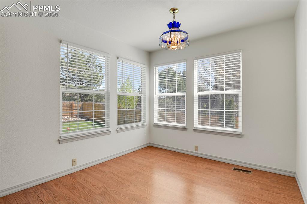 Image 13 of 50: Room featuring hardwood style flooring, white walls, and a decorative ceili