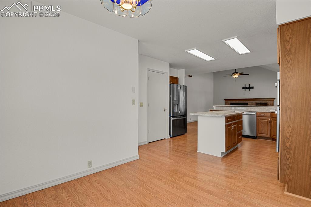 Image 14 of 50: The kitchen features a center island, stainless steel appliances, and wood 