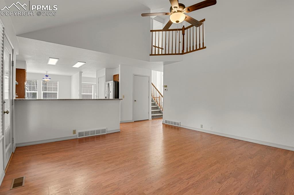 Image 16 of 50: Living area featuring wood flooring, a ceiling fan with light fixture, and 