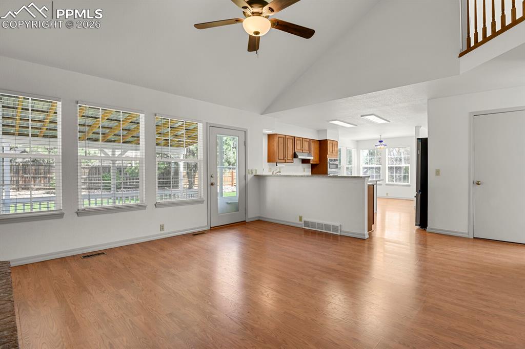 Image 17 of 50: This inviting living space features hardwood flooring, a vaulted ceiling wi