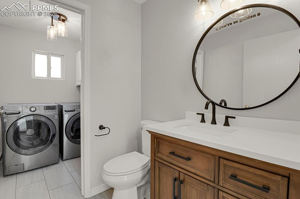 Image 19 of 50: Bathroom featuring a wooden vanity with dark hardware, a white countertop, 