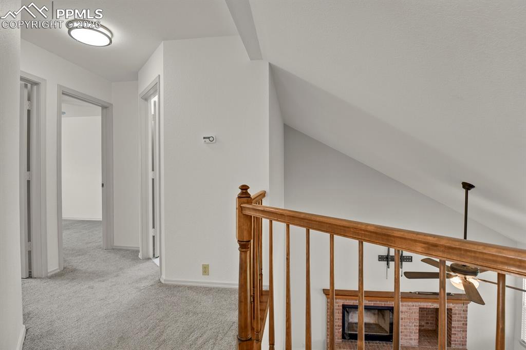 Image 22 of 50: The property features a staircase with a wooden railing, light-colored carp