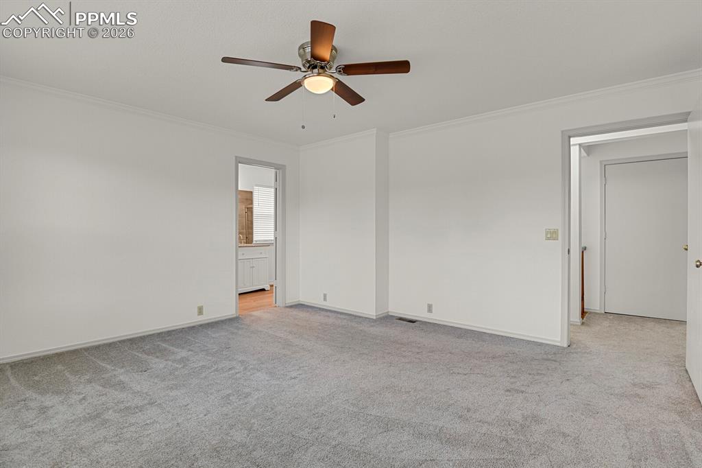 Image 24 of 50: The property features a spacious room with light gray carpeting, white wall