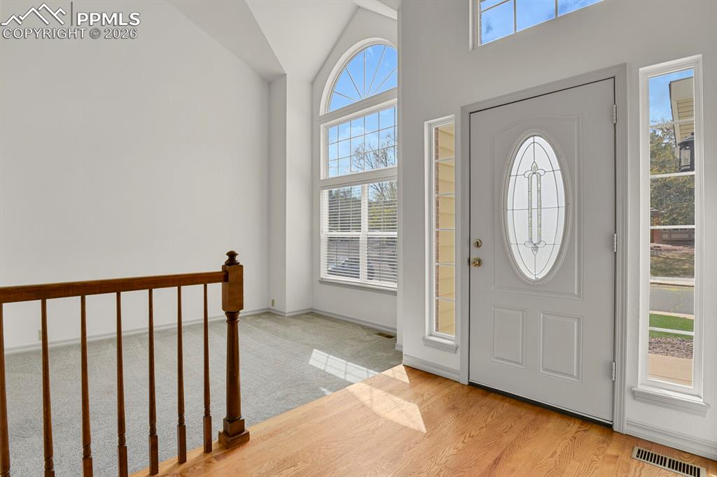 Image 3 of 50: Entryway featuring hardwood floors, a white door with decorative glass, and