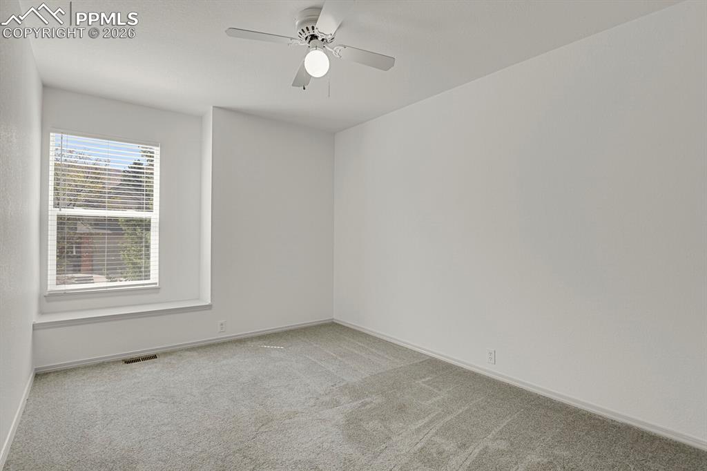 Image 30 of 50: Bright room featuring a window with blinds, light gray carpeting, and a cei