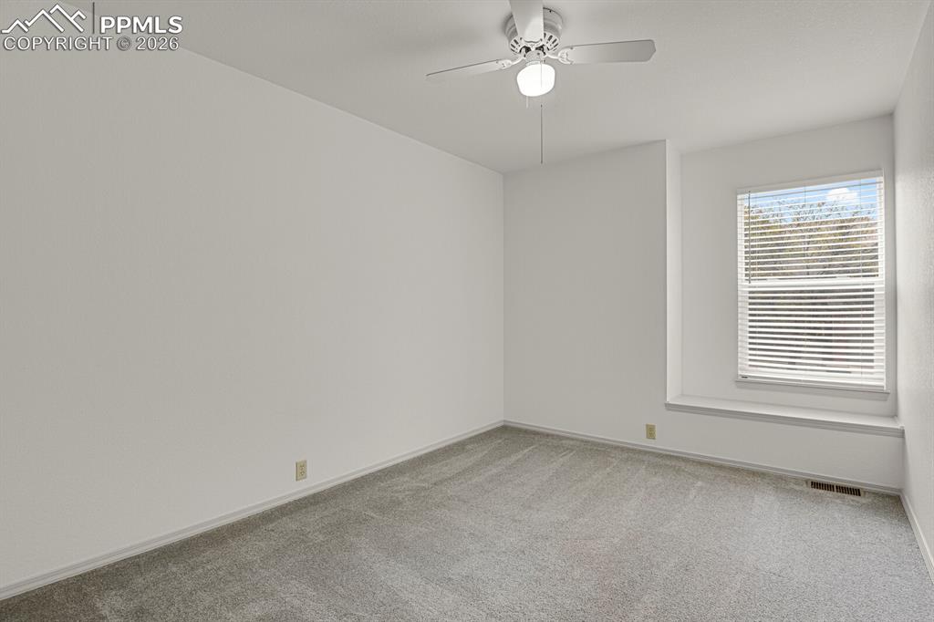 Image 32 of 50: This room features a window with blinds, a window sill, and a ceiling fan w
