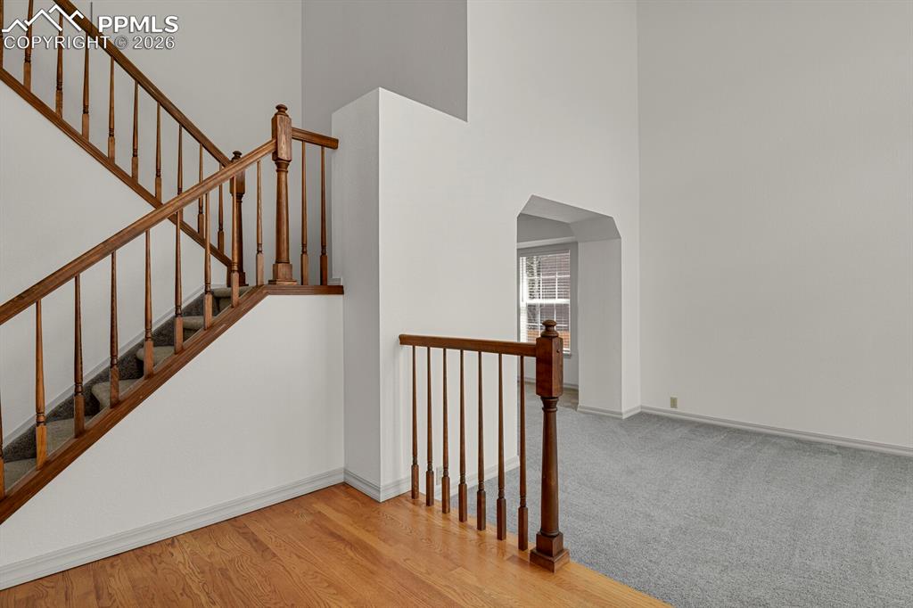 Image 4 of 50: The property features a staircase with wooden railings and carpeted treads,