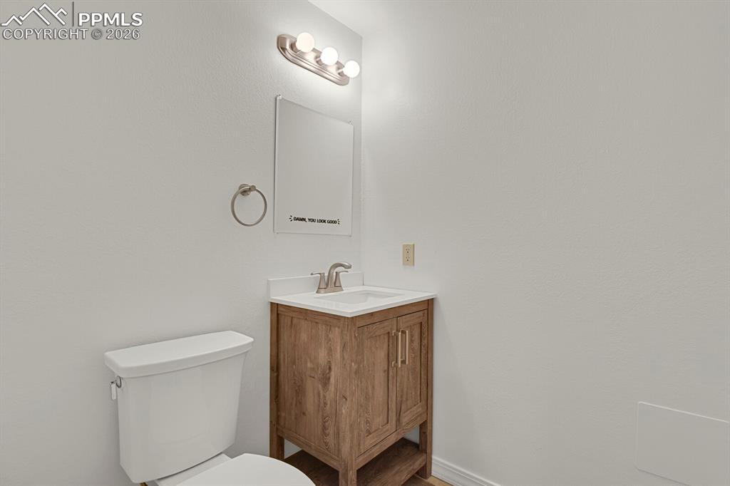 Image 40 of 50: Bathroom featuring a vanity with a wood-look finish, white countertop, and 